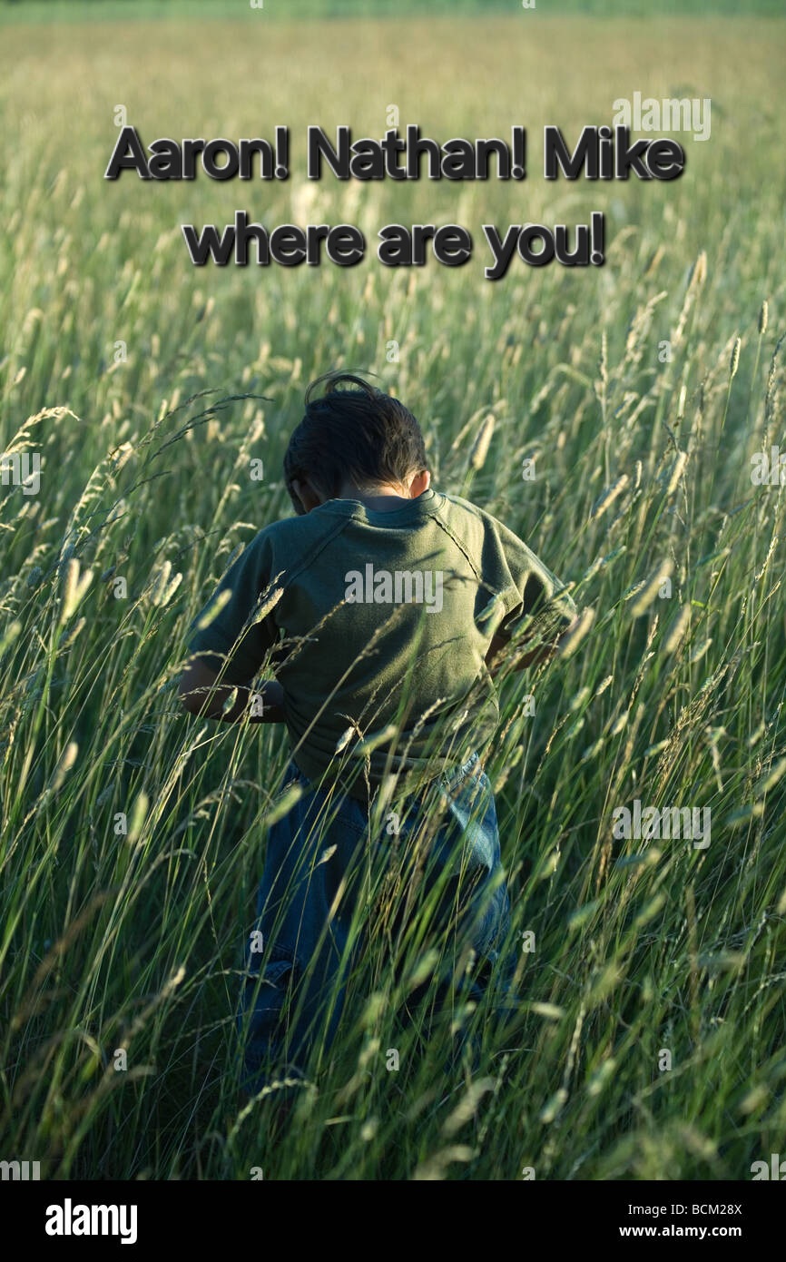 little-boy-standing-in-tall-grass-head-down-rear-view-BCM28X.jpg