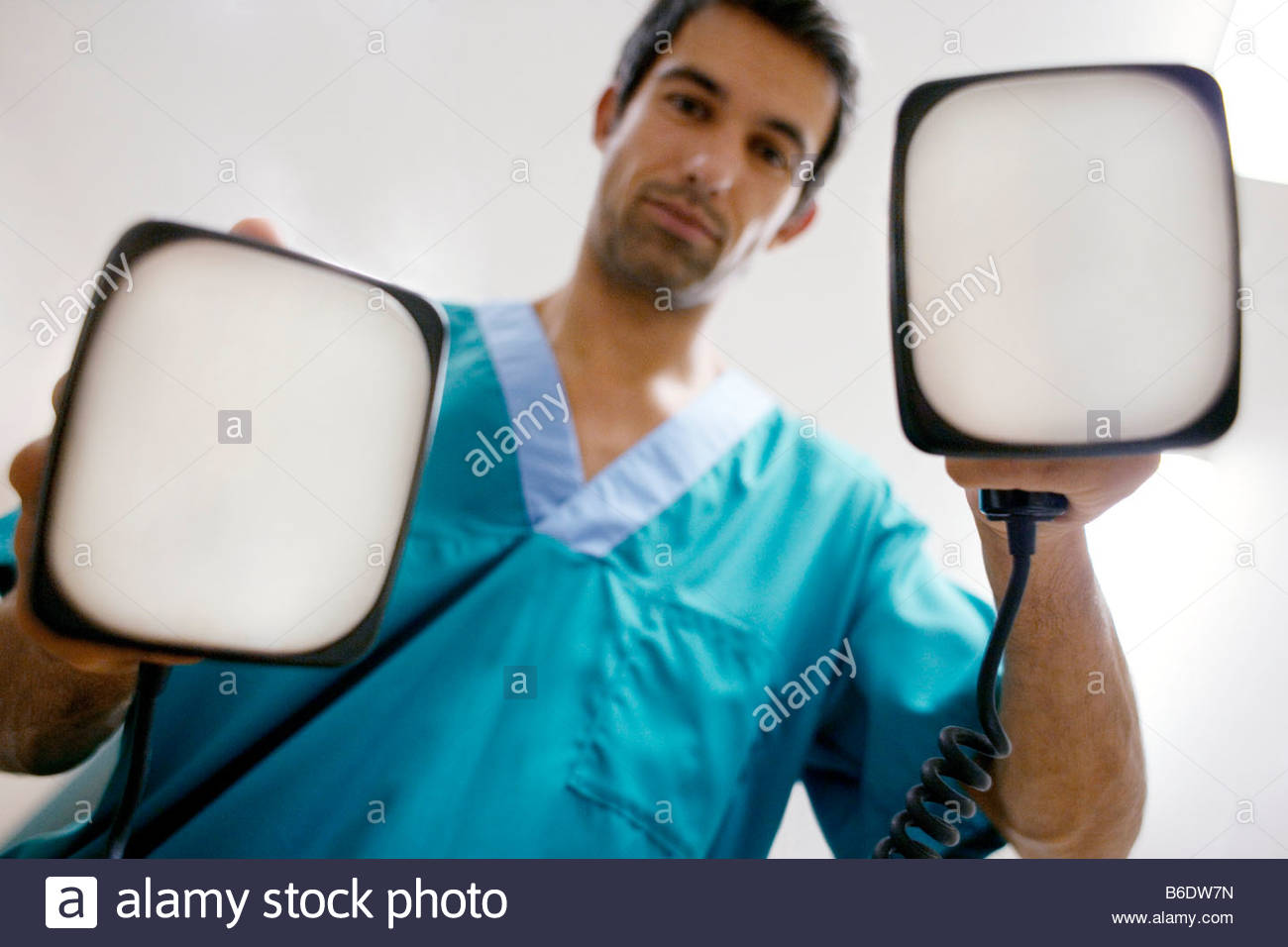 emergency-defibrillation-doctor-holding-defibrillation-electrode-paddles-B6DW7N.jpg
